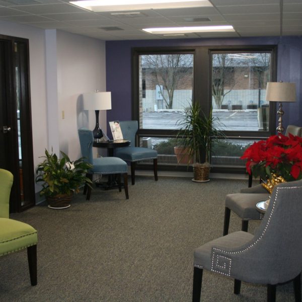 another angle of our waiting room showing grey, green, and blue chairs and a window