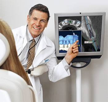 Male dentist showing a patient the results of her CBCT scan