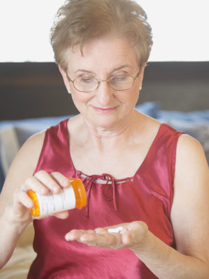 a woman pouring some pills into her hand and smiling down at them